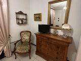 a chair and a dresser in a room with a mirror on the wall