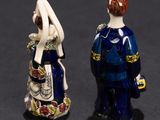two figurines of a man and a woman standing next to each other