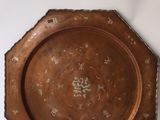 une plaque de cuivre ancienne ornée d'un motif floral