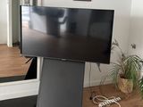 a flat screen tv sitting on top of a stand in a living room