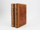 a pair of old books sitting on top of each other