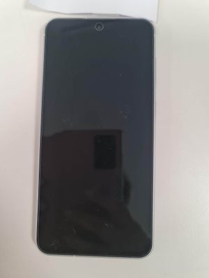 un gros plan d'un téléphone portable posé sur une table, à côté d'une boîte