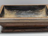 an old wooden box with a metal lid sitting on a table