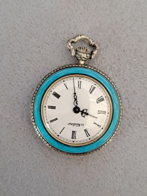 une montre de poche bleue et blanche ornée de chiffres romains
