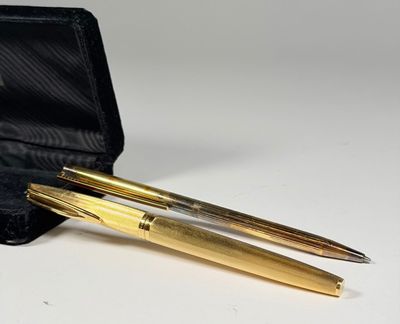 deux stylos dans un étui noir posé sur une table blanche