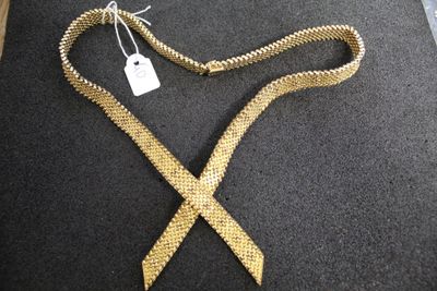 a gold tie with a tag on it on a black surface