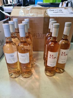 Plusieurs bouteilles de vin sont posées sur une table devant une boîte