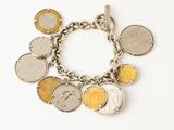 a silver bracelet with a bunch of coins on it