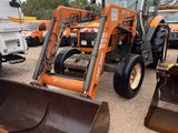 a tractor and a tractor loader parked in a parking lot
