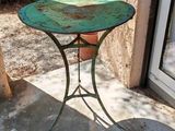 une table verte sur laquelle se trouve une plante en pot