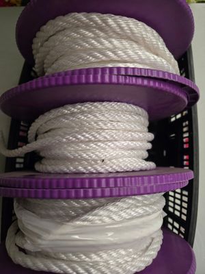 Plusieurs cordes blanches sont empilées les unes sur les autres dans un panier