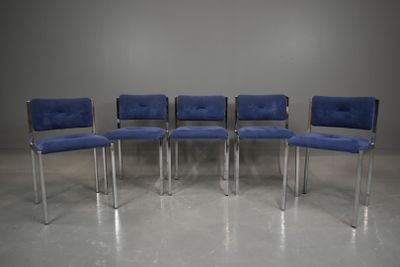 quatre chaises bleues aux pieds chromés dans une pièce aux murs gris