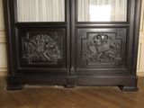 a black cabinet with two doors and a clock on it