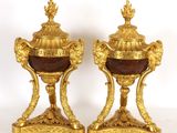 paire d'urnes anciennes en marbre doré et rouge, posées sur des socles