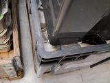 a black oven sitting on top of a wooden pallet next to a stack of books