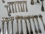 many forks and spoons laid out on the table