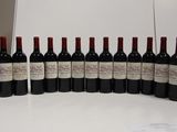 several bottles of wine are lined up on a white table