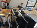 Plusieurs écrans d'ordinateur sont posés sur un bureau devant une fenêtre.