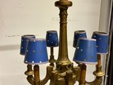 a gold chandelier with blue lamps hanging from it