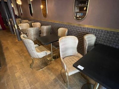 tables and chairs are lined up in a restaurant with mirrors on the wall