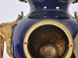 a large blue vase with a gold decoration on it