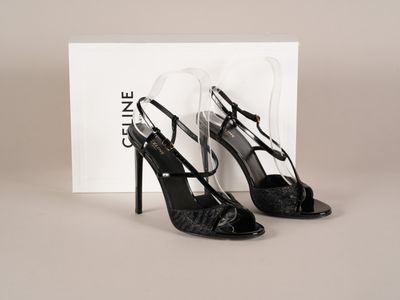 une paire de chaussures noires à talons hauts posée sur une boîte blanche