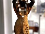 une statue représentant une femme tenant un pot sur la tête