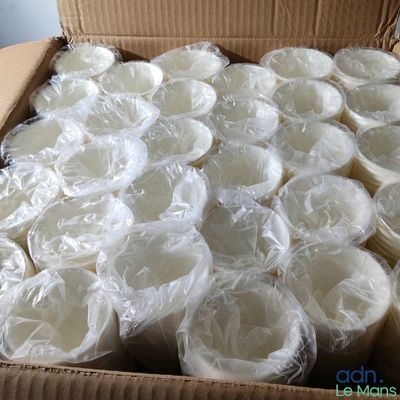 une boîte en carton remplie de gobelets en plastique et enveloppée dans du film alimentaire