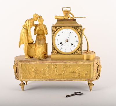 a gold clock sitting on top of a table with a key
