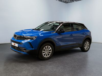 Un SUV bleu est garé dans une grande pièce.