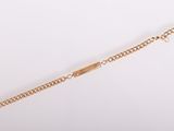 gros plan d'un bracelet en or sur fond blanc