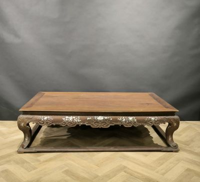 a wooden coffee table with ornate carvings on the top