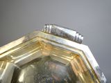 a silver plate with a silver handle on a table