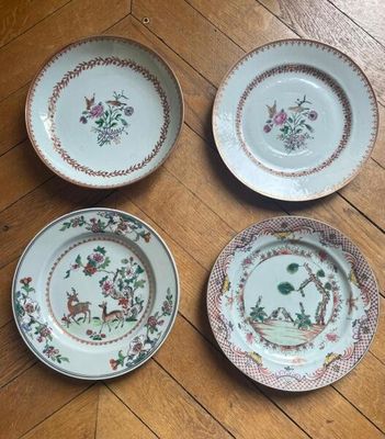 three plates with floral designs on them sitting on a wooden floor