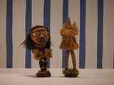 two small wooden figurines that are standing next to each other