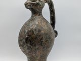 a small vase with a handle on a white background
