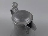 an antique pewware pitcher with a lid and a handle