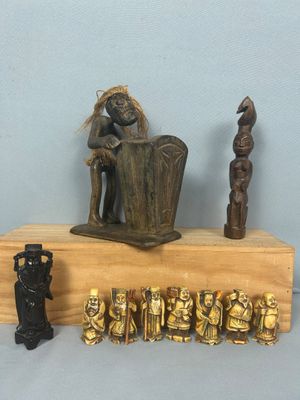 une statue représentant un homme assis sur une étagère en bois