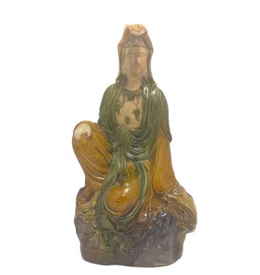une statue représentant une femme assise sur un rocher