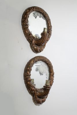 two mirrors are hanging on a wall in a room