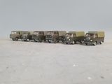 toy army vehicles are lined up in a row on the ground