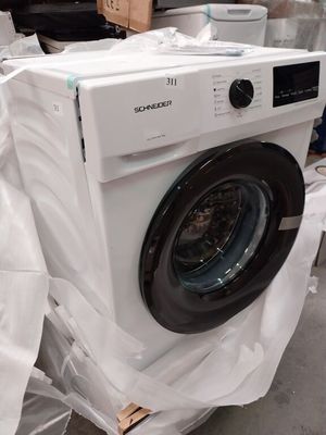 une machine à laver posée au milieu d'une pile de cartons