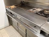 stainless steel counter top in a commercial kitchen with two burners and a griddle