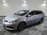 La Toyota Corolla argentée est garée dans une pièce dont le sol est en damier.