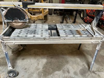 un établi métallique équipé d'une scie, dans un garage