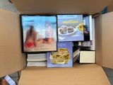 une boîte en carton remplie de livres et de magazines posée par terre