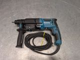a close up of a drill on a metal surface with a cord