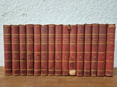 several old books are lined up on a wooden table