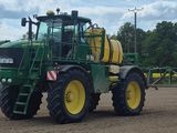 un tracteur équipé d'un pulvérisateur à l'arrière, dans un champ