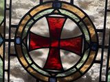 a stained glass window with a red cross on it